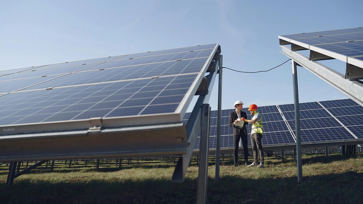 Engineers inspecting solar panels at an installation site.
